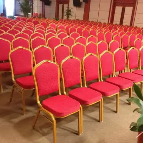 Rows of red banquet chairs with gold frames