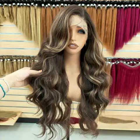 A long dark-brown body-wave wig with lighter highlights on a mannequin in a hair shop.