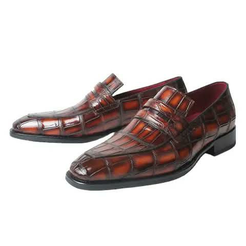 Men's loafers with a brown croc pattern and red lining.