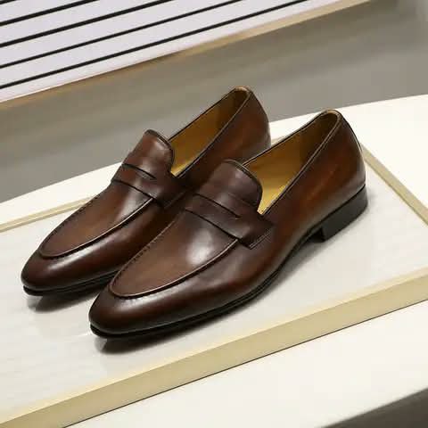 Brown penny loafers on a display tray.