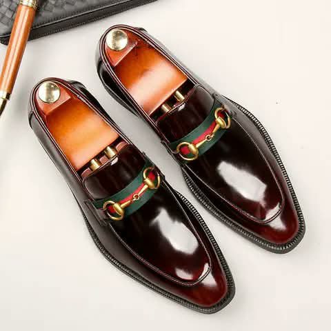 Burgundy loafers with a striped strap and gold bit.