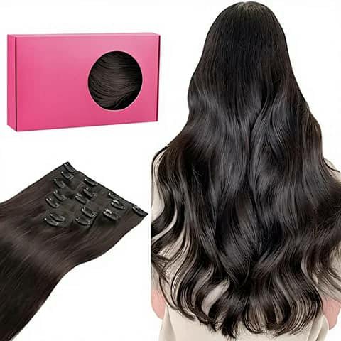Clip-in hair extensions in black beside a pink box and a woman wearing long wavy black hair.