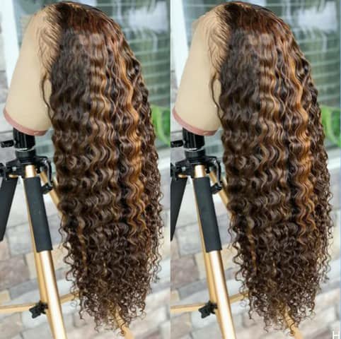 A long curly wig with brown highlights shown on a stand from two angles.