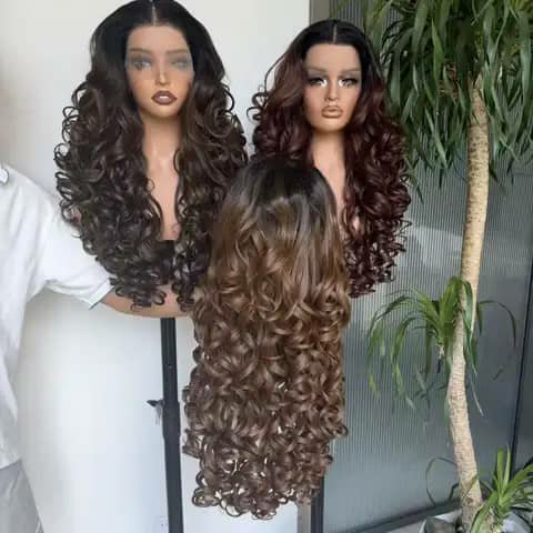 Three long curly wigs in shades of brown on mannequin heads.