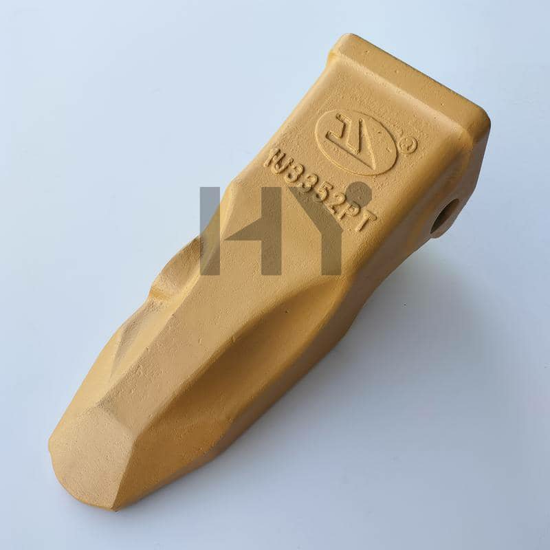 A single tan excavator bucket tooth with markings on a light background.