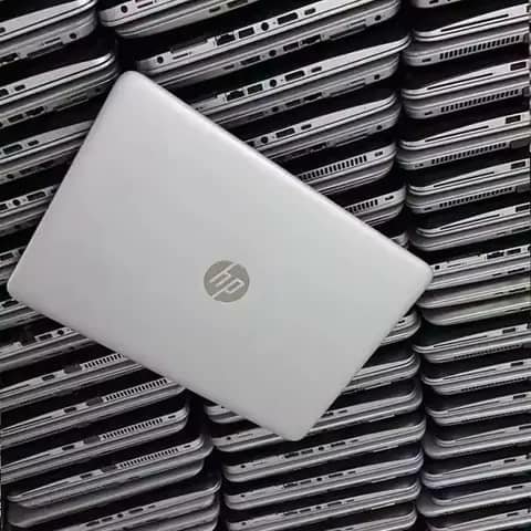 Silver HP laptop resting on a stack of laptops