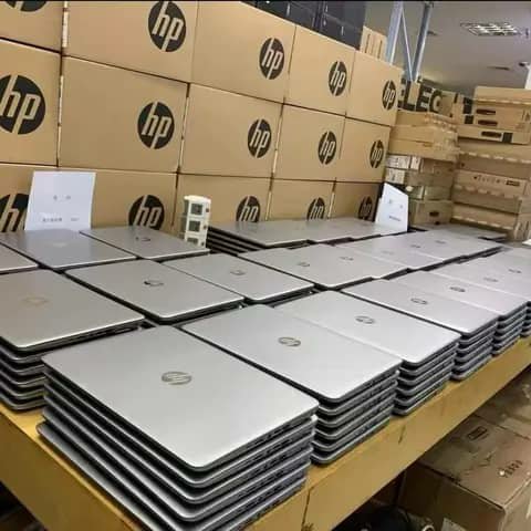 HP laptops stacked on a table, HP cartons behind