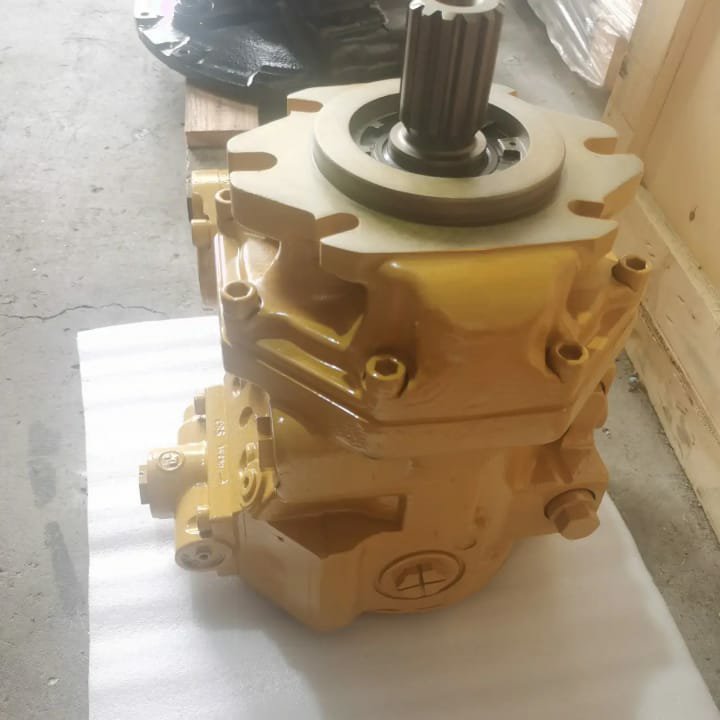 A tan hydraulic pump with a splined shaft pointing up, on white cloth.
