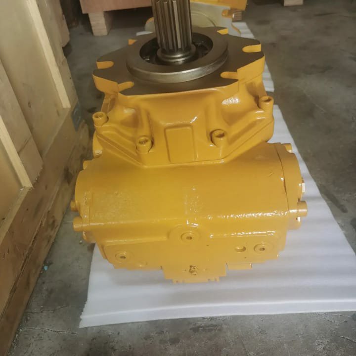 A yellow hydraulic pump with a splined shaft pointing up, on white cloth.