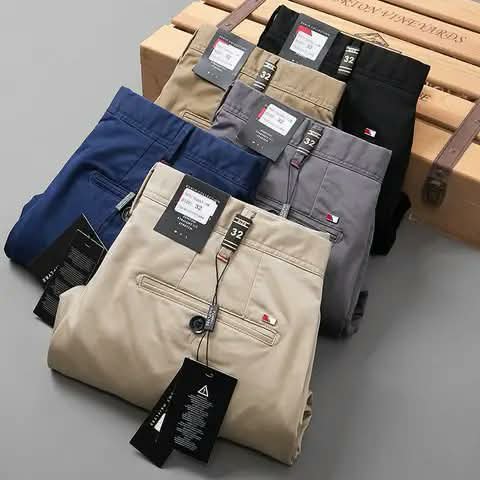 Men's chino trousers with their tags, in five colours.
