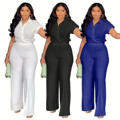 Three women wearing matching short-sleeve shirt and wide-leg trouser sets in white, black and blue.