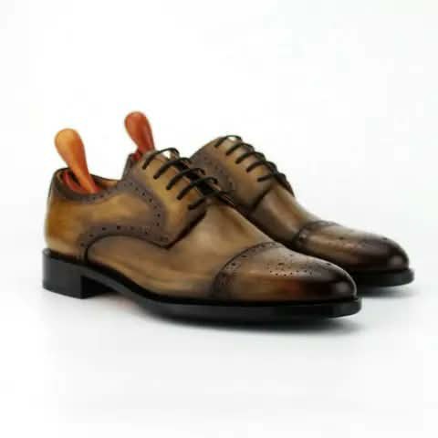 Tan brogue Oxford shoes with wooden shoe trees.