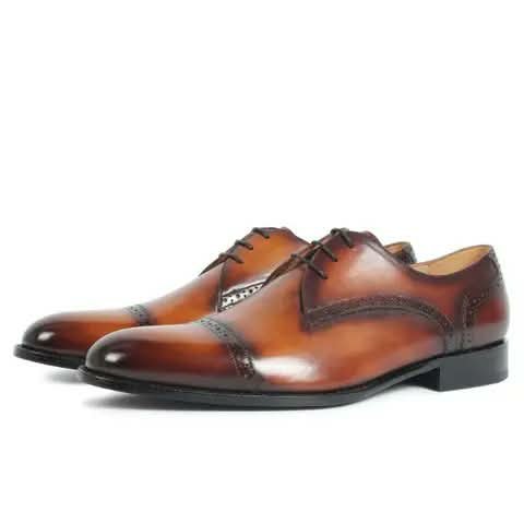 Tan cap-toe Oxford shoes.